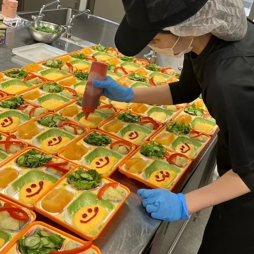 にじいろ弁当のかわいいオムレツを調理するスタッフ